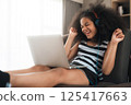 Happy girl using laptop at home 125417663