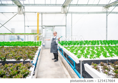 Happy senior Asian man in greenhouse Happy senior Asian man in greenhouse 125417664