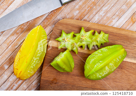 Cut fresh juicy cannon fruits on wooden background 125418710