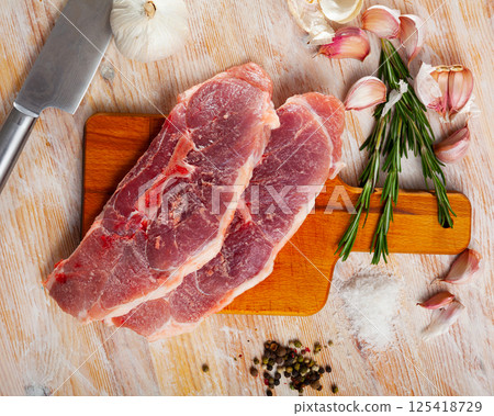 Close up of raw pork's fillet shoulder with garlic and rosemary Close up of raw pork's fillet shoulder with garlic and rosemary 125418729