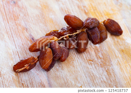 Tasty dried date on wooden table close up, mediterranean fruit Tasty dried date on wooden table close up, mediterranean fruit 125418737