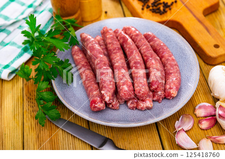 Raw longaniza from minced pork on plate. Popular Catalan sort of sausages Raw longaniza from minced pork on plate. Popular Catalan sort of sausages 125418760