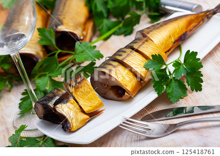 Image of sliced smoked mackerel fish served with greens 125418761