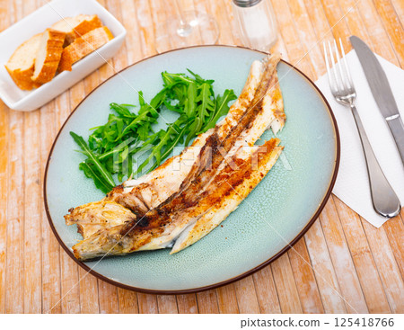 Fresh baked fish sea bass with arugula Fresh baked fish sea bass with arugula 125418766