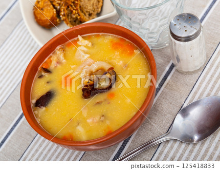 Hot pea soup with smoked meats and vegetables 125418833