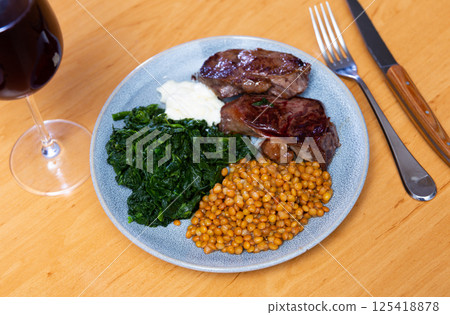 Beef with lentils and spinach served on platter Beef with lentils and spinach served on platter 125418878