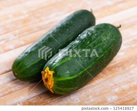 Cucumbers and knife on wooden cutting board Cucumbers and knife on wooden cutting board 125418927