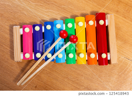 Kids xylophone with rainbow metal bars and wooden mallets 125418943