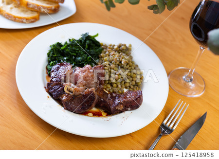 Beef with lentils and spinach served on platter Beef with lentils and spinach served on platter 125418958