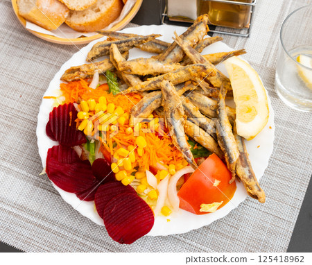 Dish with fried sardines, pilchards or anchovies in batter for traditional Spanish meal Dish with fried sardines, pilchards or anchovies in batter for traditional Spanish meal 125418962