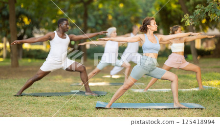 Group pilates and yoga classes in summer park for people of different nationalities Group pilates and yoga classes in summer park for people of different nationalities 125418994