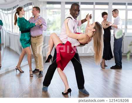 Man and young woman practicing waltz in dancing studio Man and young woman practicing waltz in dancing studio 125419206