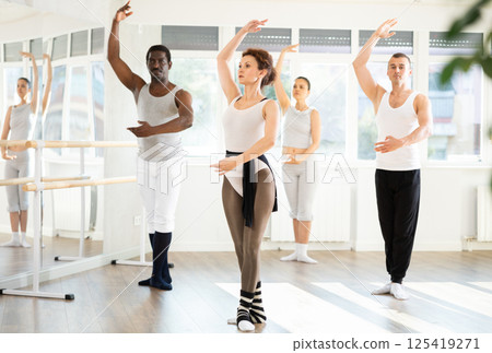 Group of men and women stand in third position 125419271