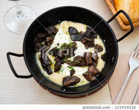 Tasty dish of eggs with mushrooms served in potato casserole Tasty dish of eggs with mushrooms served in potato casserole 125419316