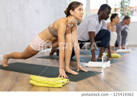 Young sporty woman doing Ashwa Sanchalanasana lunging yoga pose Young sporty woman doing Ashwa Sanchalanasana lunging yoga pose 125419362