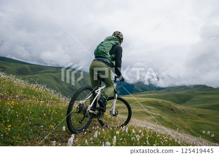 Riding mountain bike on beautiful grassland mountain top 125419445