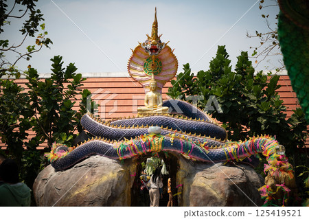 Chonburi, Thailand, Febuary 12, 2025, Golden Buddha statue adorns the entrance of Wat Hupbon Wanaram amidst vibrant decorations in February 125419521