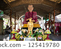 Singburi, Thailand, March 23, 2025, Impressive statue of monk and golden figure displayed in an ornate setting at Wat Phra Non Chak Si Worawihan 125419780