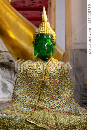 Singburi, Thailand, March 23, 2025, Stunning emerald Buddha statue adorned with intricate golden clothing at Wat Phra Non Chak Si Worawihan Singburi, Thailand, March 23, 2025, Stunning emerald Buddha statue adorned with intricate golden clothing at Wat Phra Non Chak Si Worawihan 125419789