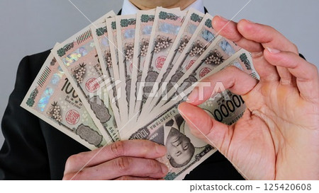 A businessman posing with the new 10,000 yen bill 125420608