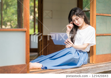 年輕女子在平板電腦上觀看影片時哭泣 年輕女子在平板電腦上觀看影片時哭泣 125420843