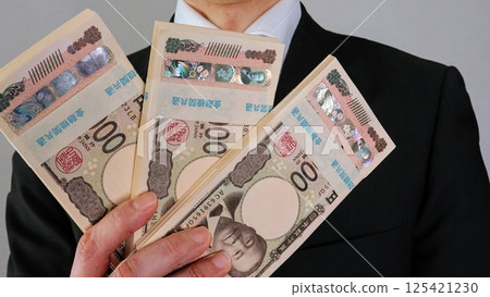 日本商人拿著一疊鈔票 日本商人拿著一疊鈔票 125421230