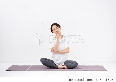 Woman doing yoga, middle-aged, worried 125421396