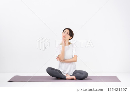 Woman doing yoga, middle-aged, worried 125421397
