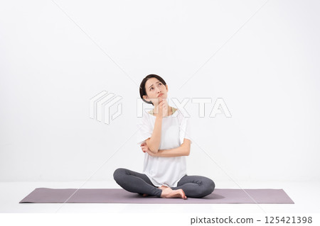 Woman doing yoga, middle-aged, worried 125421398