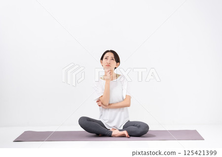 Woman doing yoga, middle-aged, worried 125421399