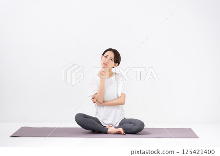 Woman doing yoga, middle-aged, worried 125421400