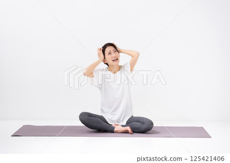 做瑜珈的中年婦女，抱著頭 125421406
