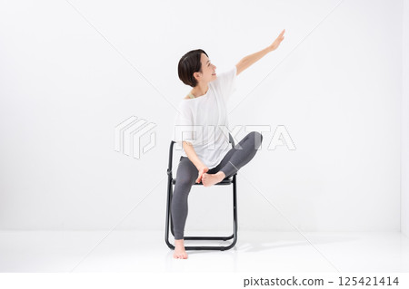 Woman doing chair yoga, middle-aged Woman doing chair yoga, middle-aged 125421414