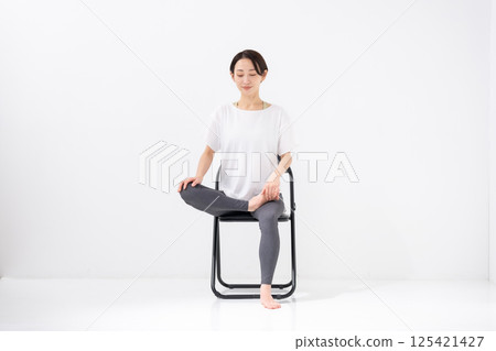 Woman doing chair yoga, middle-aged Woman doing chair yoga, middle-aged 125421427