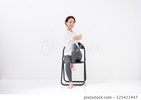 Woman doing chair yoga, middle-aged Woman doing chair yoga, middle-aged 125421447