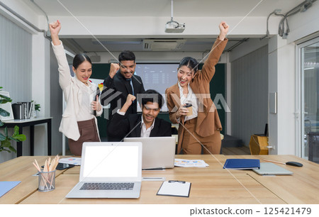 A pivotal moment where a group of ambitious business personalities, each individual with their own unique story to tell, gather around a table, fists raised high in solidarity and victory. A pivotal moment where a group of ambitious business personalities, each individual with their own unique story to tell, gather around a table, fists raised high in solidarity and victory. 125421479
