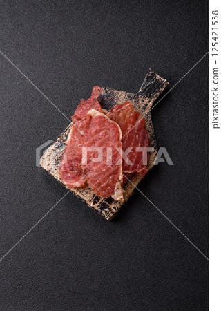 Jerky, dried pork meat slices with salt and spices 125421538