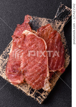 Jerky, dried pork meat slices with salt and spices Jerky, dried pork meat slices with salt and spices 125421542