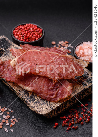 Jerky, dried pork meat slices with salt and spices 125421546