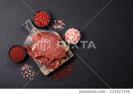 Jerky, dried pork meat slices with salt and spices 125421548