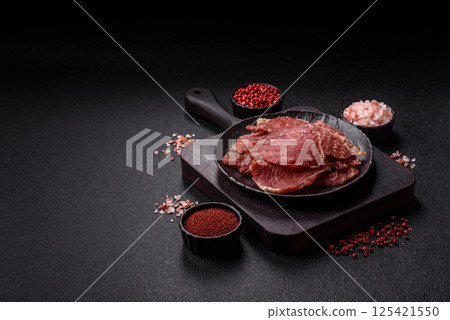 Jerky, dried pork meat slices with salt and spices Jerky, dried pork meat slices with salt and spices 125421550