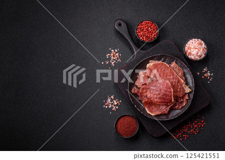 Jerky, dried pork meat slices with salt and spices 125421551