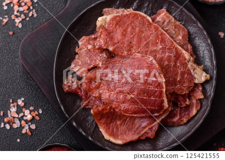 Jerky, dried pork meat slices with salt and spices Jerky, dried pork meat slices with salt and spices 125421555