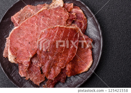Jerky, dried pork meat slices with salt and spices 125421558