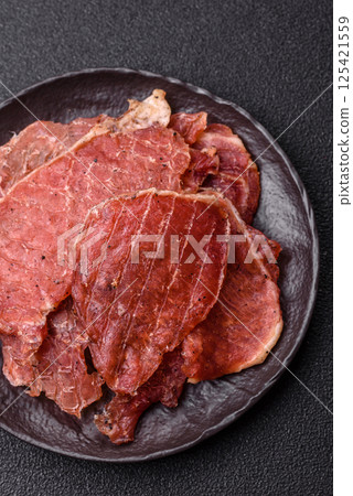 Jerky, dried pork meat slices with salt and spices 125421559