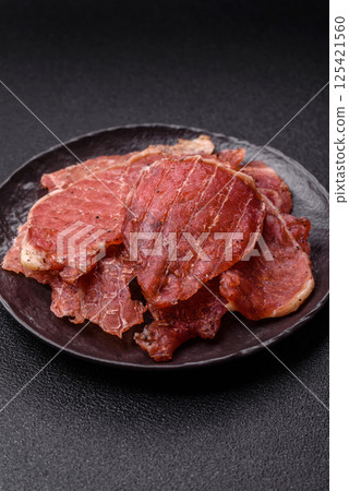 Jerky, dried pork meat slices with salt and spices 125421560