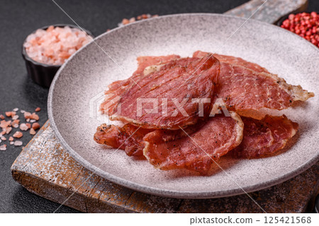 Jerky, dried pork meat slices with salt and spices Jerky, dried pork meat slices with salt and spices 125421568