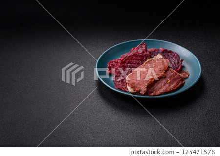 Jerky, dried pork meat slices with salt and spices Jerky, dried pork meat slices with salt and spices 125421578