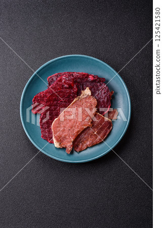 Jerky, dried pork meat slices with salt and spices Jerky, dried pork meat slices with salt and spices 125421580