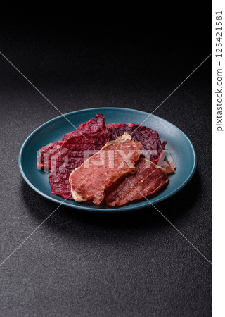 Jerky, dried pork meat slices with salt and spices 125421581
